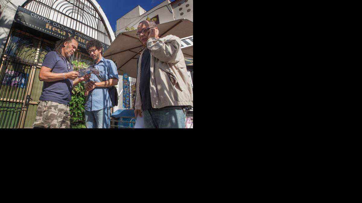 
El cineasta cubano Ricardo Figueredo (centro) muestra un folleto sobre su próximo documental a un actor cubano, el 9 de enero en La Habana. El difícil acceso a Internet en la isla obliga a Figueredo a tener que intentar recolectar fondos para su película en las calles de la ciudad. 
