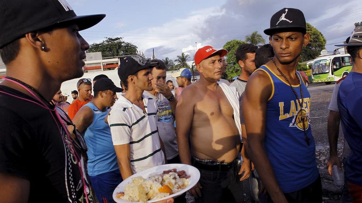 Decenas de cubanos hacen cola para recibir una ración de comida en el albergue de Paso Canoas, Costa Rica, el martes 22 de diciembre.