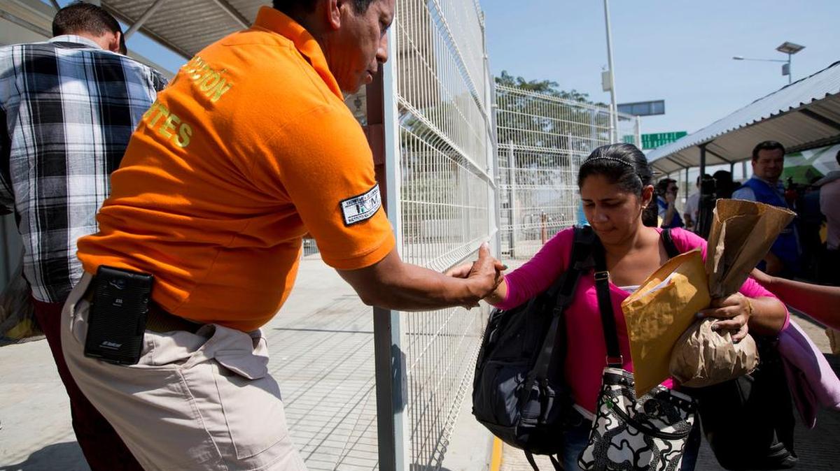 Un agente mexicano de inmigración ayuda a una migrante cubana en la ciudad de Hidalgo, México.