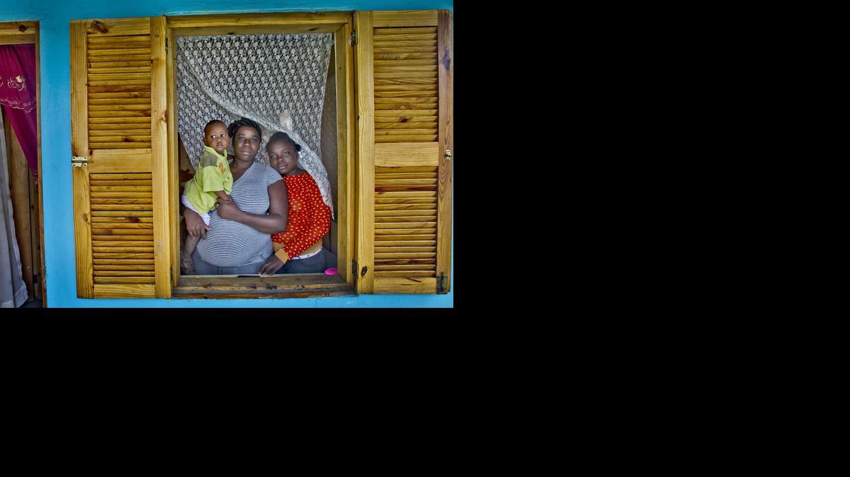 
Islande Lima junto a su hija Dalandsie Pascal, de 11 años, y un niño de una familia amiga, en su casa de la urbanización inmobiliaria Caracol-EKAM, construida por la USAID.


