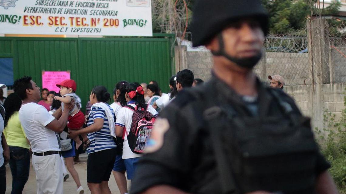 Un polícia custodia en las afueras de una escuela, durante un operativo de seguridad por amenazas de crimen organizado dirigido a los profesores.
