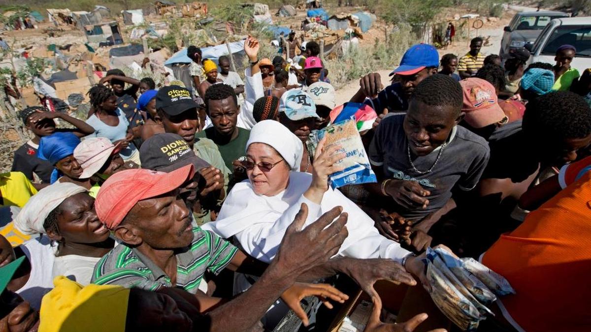 Una monja distribuye en agosto pasado arroz y otros productos alimenticios a haitianos que fueron deportados o que huyeron de R. Dominicana, y que se encontraban acampando en Anse-a-Pitres, Haití.