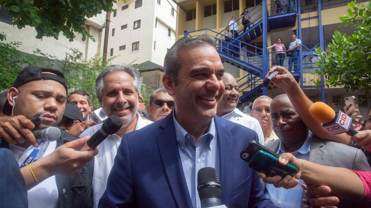 Luis Abinader (centro), quien fuera el candidato presidencial del Partido Revolucionario Moderno, habla con la prensa luego de votar el 15 de mayo.