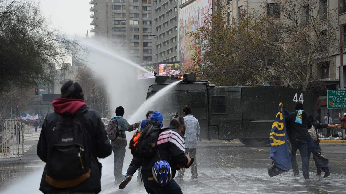 La policía antimotines en Santiago de Chile reprime el jueves con chorros de agua a estudiantes.