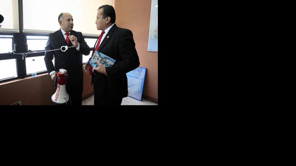 
El diputado del partido Libertad Democrática Renovada, Luis Chávez (izq.), mientras estaba encadenado en la sede del Ministerio de Desarrollo Social, en Ciudad de Guatemala.
