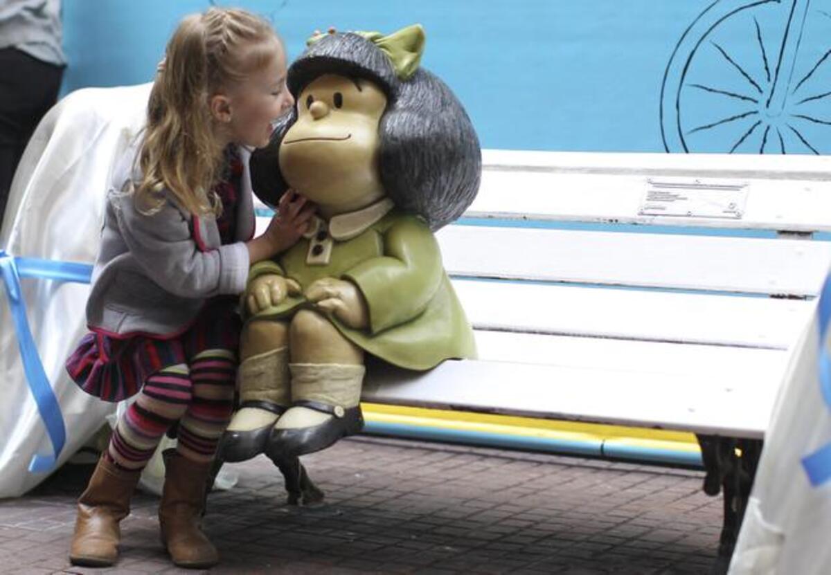 Una niña toca la figura de Mafalda, creación del dibujante argentino Joaquín Salvador Lavado, “Quino”, durante la presentación de dos nuevas estatuas de sus personajes Manolito y Susanita, el lunes 29 de septiembre de 2014, en el Paseo de la Historieta del barrio San Telmo de Buenos Aires (Argentina). Las nuevas estatuas se instalaron con motivo del 50 aniversario de la creación del personaje Mafalda.