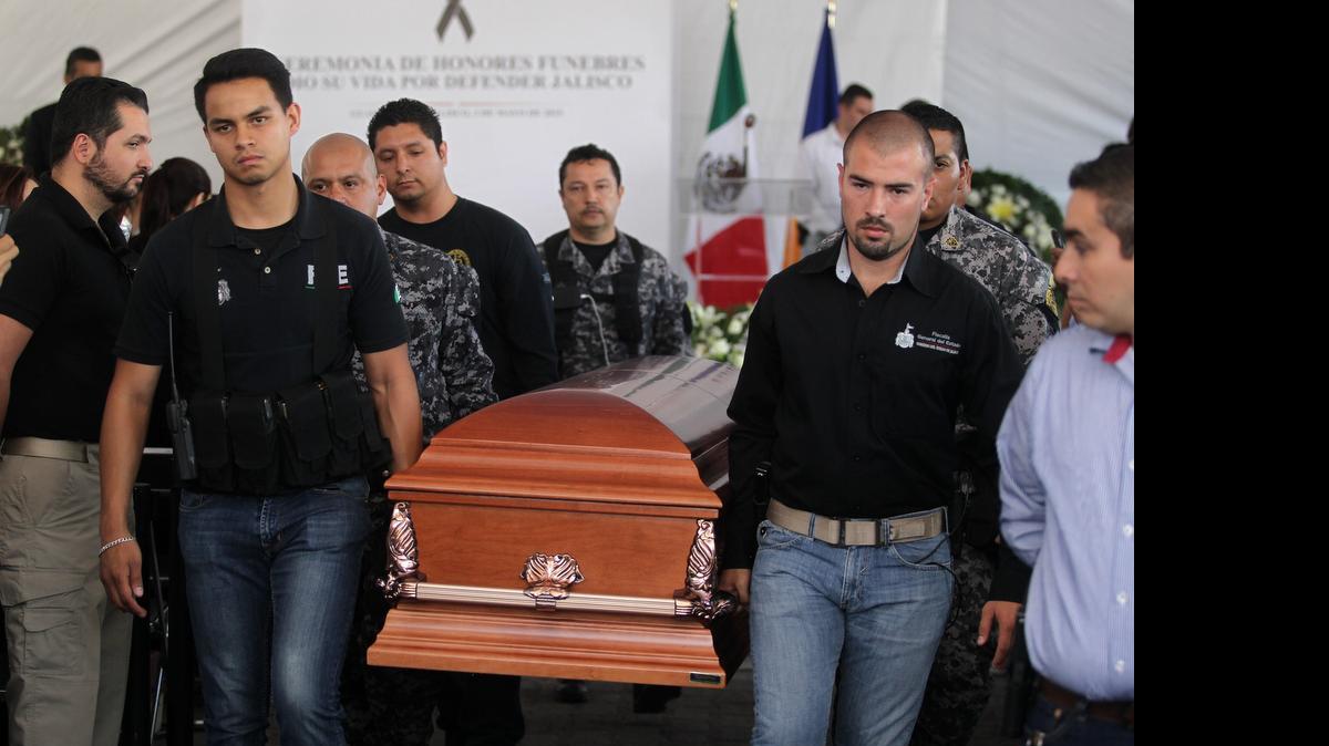 
Policías del estado mexicano de Jalisco participan el sábado trasladan el ataúd con los restos de su compañero que murió el viernes en un tiroteo en Autlán. El fiscal general Luis Carlos Nájera afirmó que la entidad está en calma luego de la jornada violenta en 25 municipios. 
