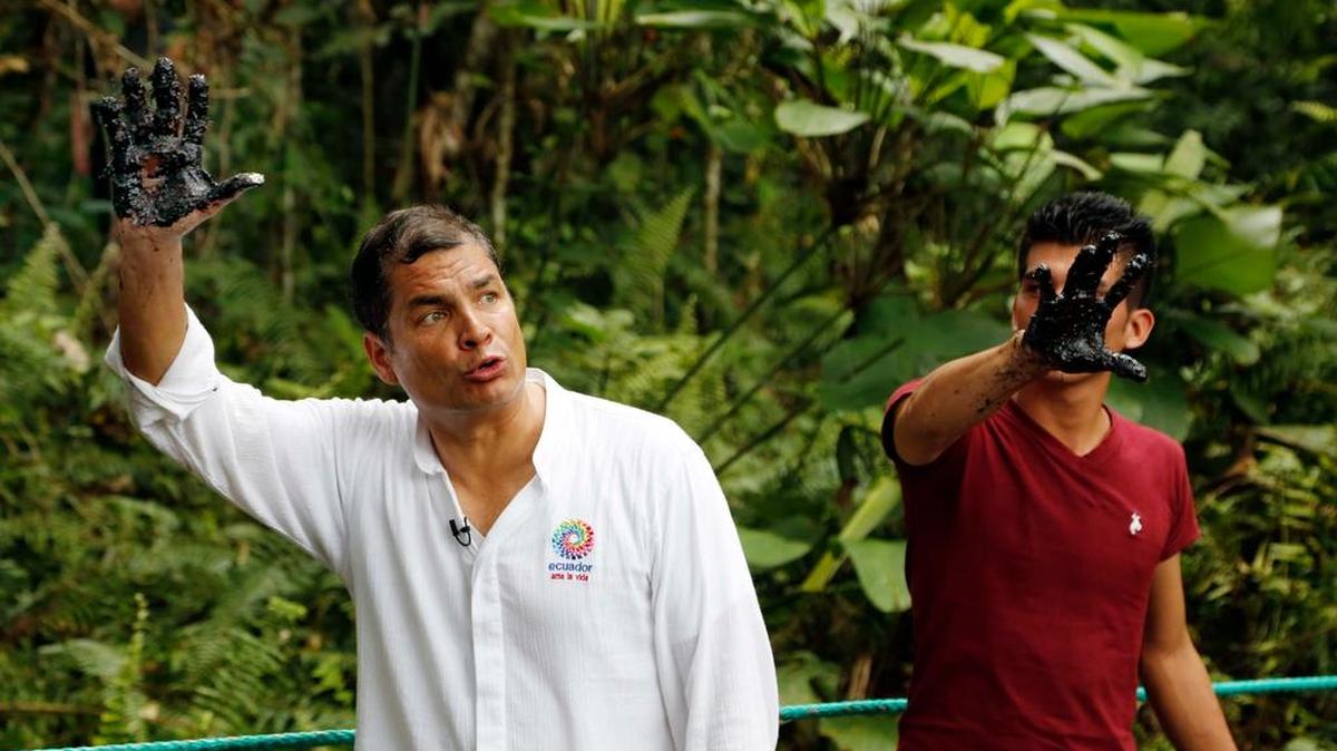 
El presidente de Ecuador, Rafael Correa, muestra su mano con un guante cubierto de petróleo en Aguarico 4, en la región amazónica, en el 2013. El martes un tribunal de EEUU emitió un dictamen a favor de Chevron, empresa con la que ese país mantiene una disputa legal arguyendo daños al medio ambiente.
