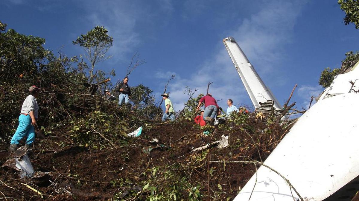 Un grupo de campesinos observa hoy, martes 29 de noviembre de 2016, los restos del avión accidentado en el municipio de La Ceja, departamento de Antioquia (Colombia).