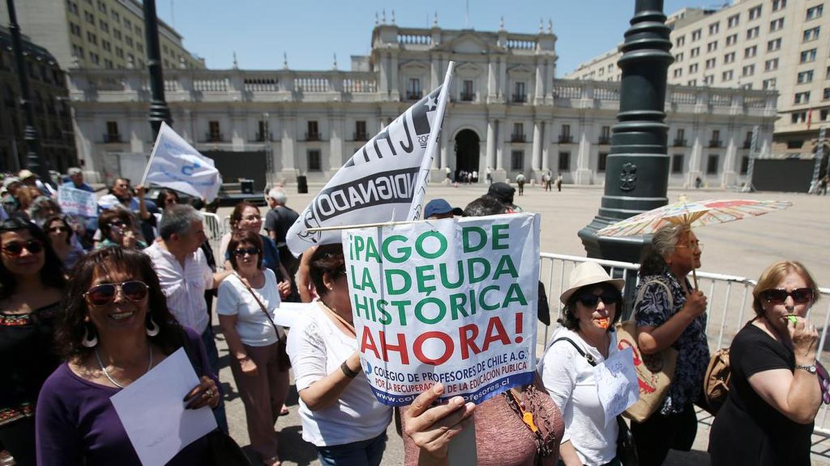 Un grupo de profesores participan en una manifestación el jueves 17 de noviembre , donde alrededor de dos mil profesores marcharon por el centro de Santiago (Chile) para exigir al Gobierno resolver el pago de la "deuda histórica" del gremio. La citada deuda, lleva más de 30 años sin ser cancelada y se originó en 1981, cuando los colegios fiscales fueron transferidos a los municipios y no se les reconoció a los profesores un ajuste especial de entre el 50 % y el 90 % del sueldo base.
