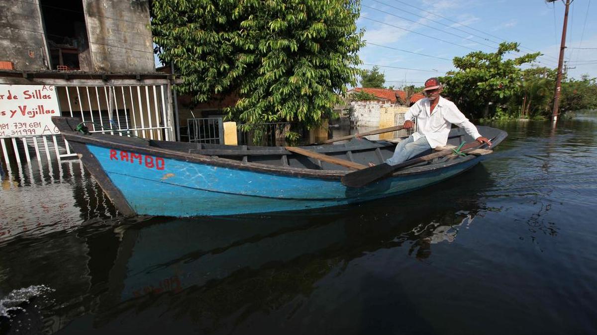 Vista de un hombre que se desplaza en canoa por un barrio de Asunción (Paraguay) inundado hoy, lunes 28 de diciembre de 2015.