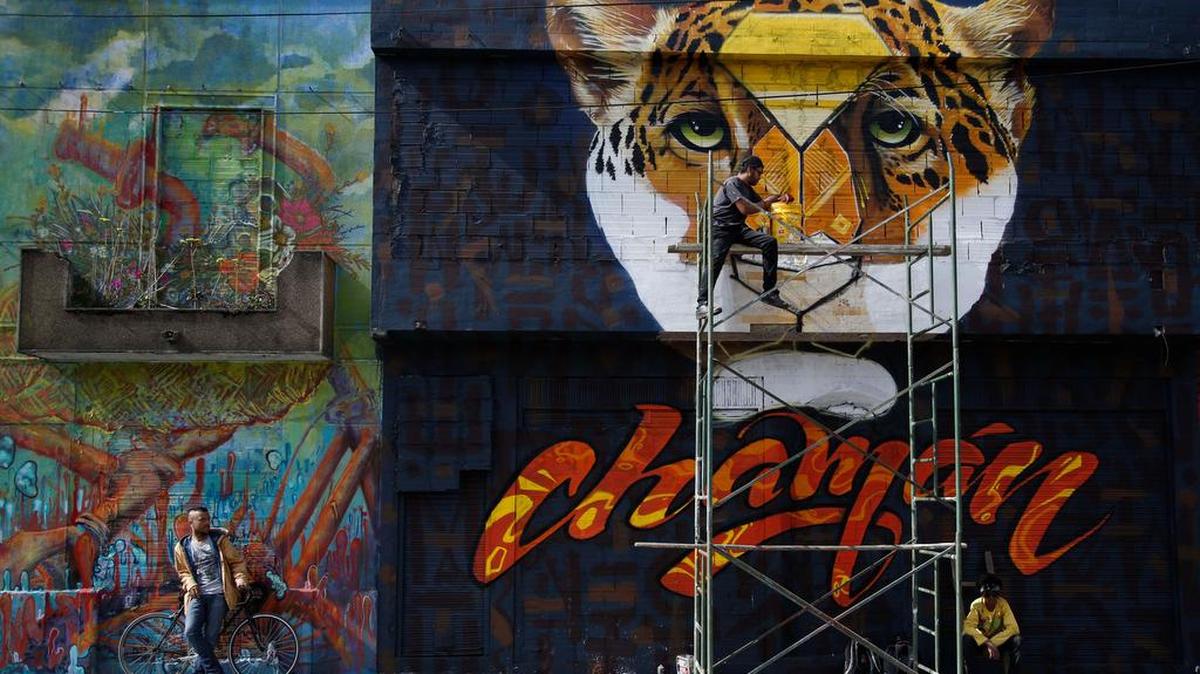 El artista colombiano Franco trabaja en un mural en Bogotá.