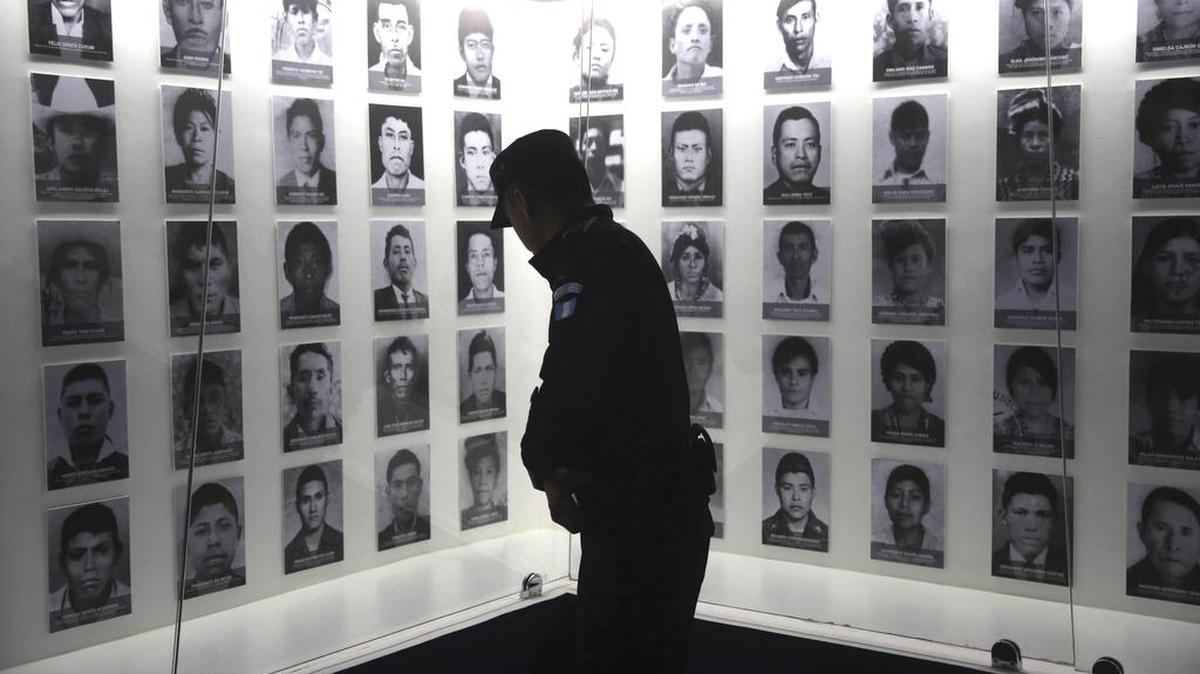 Un agente de Policía observa los rostros de víctimas de masacres en la sala del Museo Comunitario de la Memoria Histórica, ubicado en Rabinal, municipio de Baja Verapaz, Guatemala.