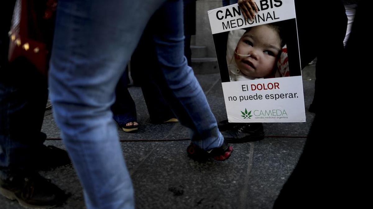 Una mujer sostiene una pancarta con un mensaje que dice: "Cannabis Medicinal, el dolor no puede esperar", frente al Senado en Buenos Aires, Argentina, el miércoles 29 de marzo de 2017.