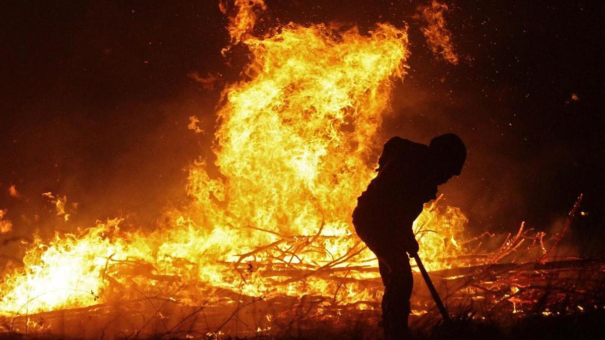 Bomberos combaten un incendio forestal la madrugada de el lunes 30 de enero de 2017, en la localidad de Portezuelo, en la provincia de -uble, al sur de Santiago (Chile).