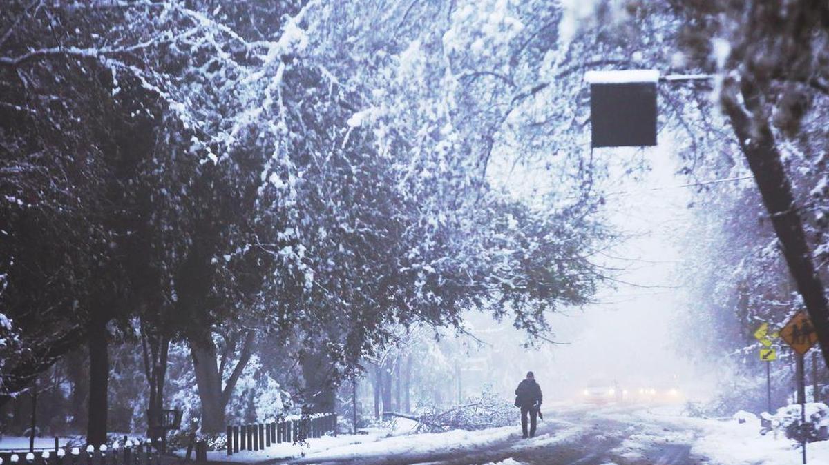 Un hombre camina por una calle cubierta de nieve el sábado 15 de julio de 2017, en Santiago (Chile).