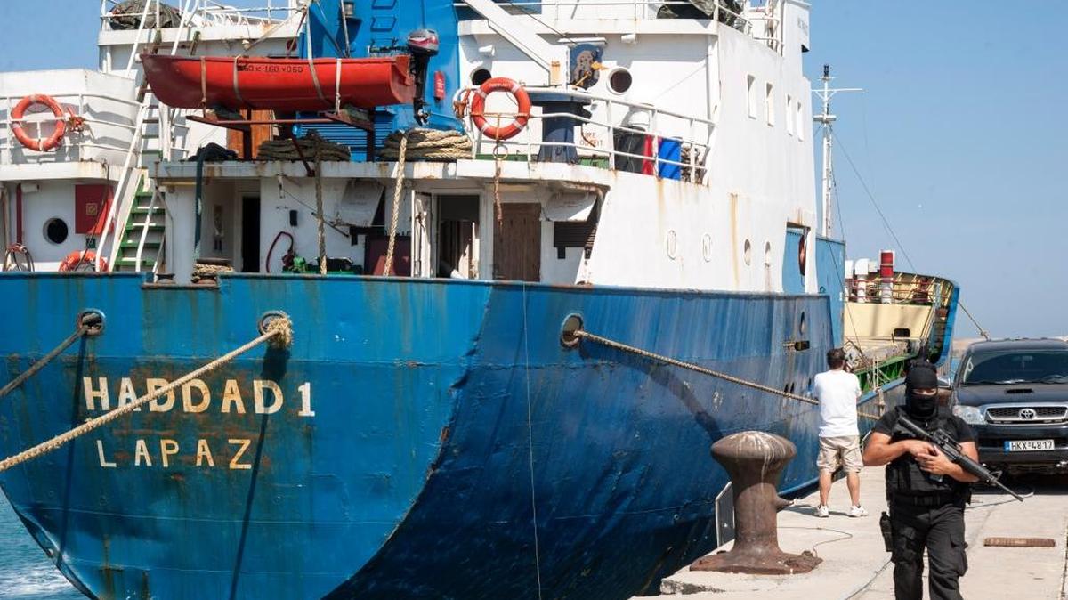 
Un agente custodia el carguero Haddad 1 el miércoles, en la isla de Crete, Grecia. El barco de bandera boliviana tenía escondidas 5,000 escopetas y medio millón de cartuchos de munición.

