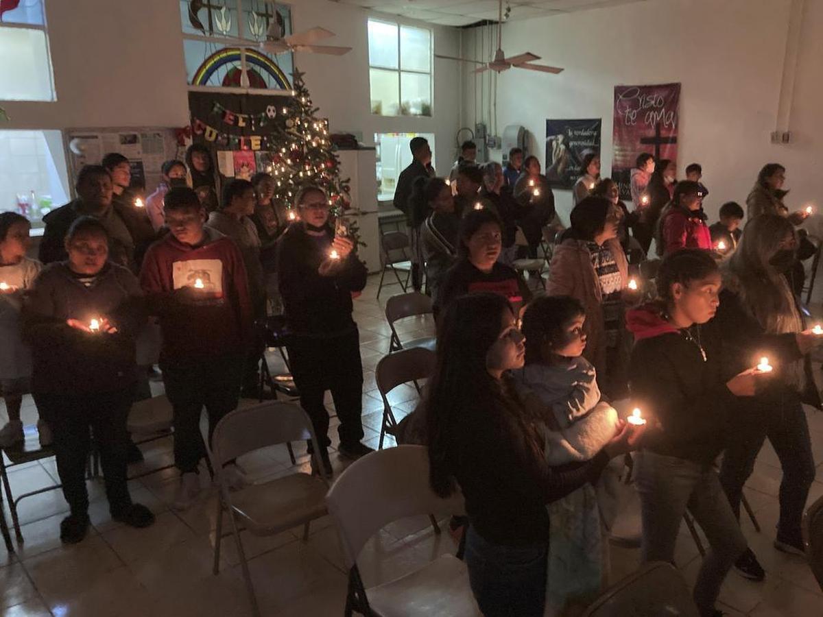 Un grupo de personas se reúnen para celebrar la Navidad en el pequeño templo metodista del albergue del Buen Samaritano en Ciudad Juárez, México.