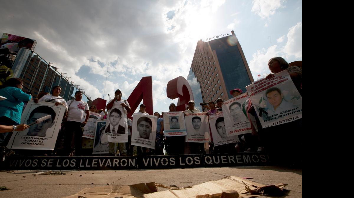 
Padres de los 43 estudiantes mexicanos desaparecidos en el 2014, sostienen pancartas con fotos de algunos de los jóvenes luego de eregir en abril pasado, en Ciudad de México, un monumento conmemorativo al cumplirse siete meses de la desaparición.
