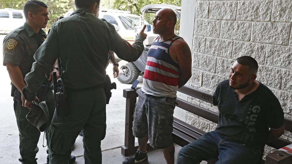 Un agente de la Patrulla Fronteriza de Estados Unidos (USBP) da de beber a un hombre esposado tras ser detenido sospechoso de haber cruzado el Río Grande para pasar ilegalmente la frontera con los Estados Unidos cerca de McAllen en Texas (Estados Unidos) el 28 de febrero de 2017.