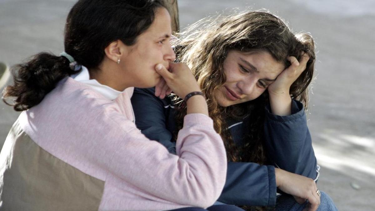Amigas se consuelan tras tiroteo en la escuela que deja seis heridos y tres muertos por un estudiante de 15 años que fue arrestado por la policia. El violento acto ocurrio en Patagonia ciudad del Carmen de Patagones en septiembre 29 del 2004.