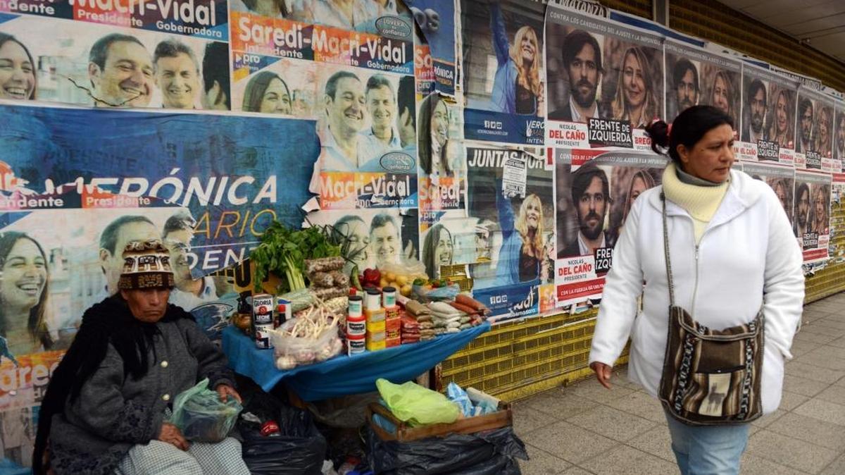 
Una mujer camina frente a una pared con propaganda política, en La Matanza, provincia de Buenos Aires.
