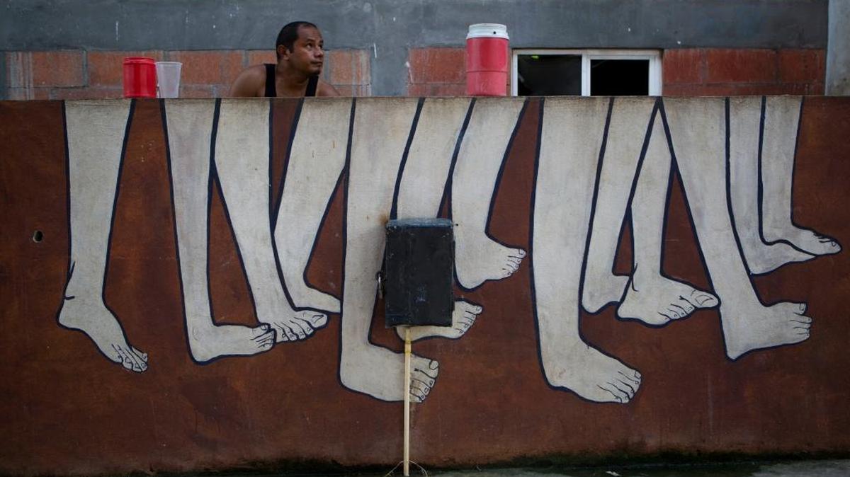 El salvadoreño William Ventura, de 35 años, lava su ropa en un lavadero público en Tenosique, México. La violencia lo hizo abandonar el país junto a su familia.
