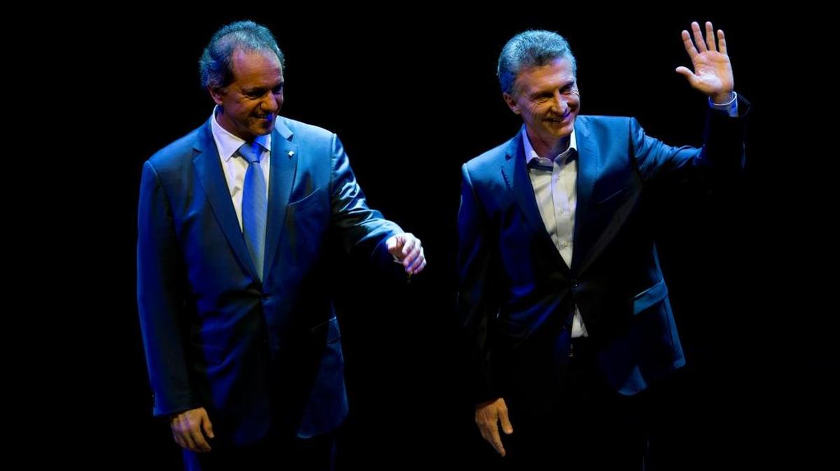 Los candidatos presidenciales de Argentina, Mauricio Macri (der.), y Daniel Scioli, saludan antes de participar en un debate en Buenos Aires, el domingo.
