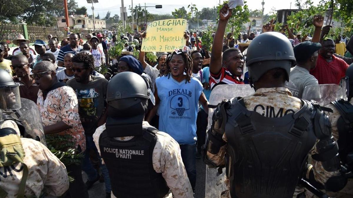 Un grupo de policías bloquean el sábado el acceso de manifestantes en Puerto Príncipe, Haití. Los manifestantes se tomaron las calles para pedir la renuncia del presidente Michel Martelly.
