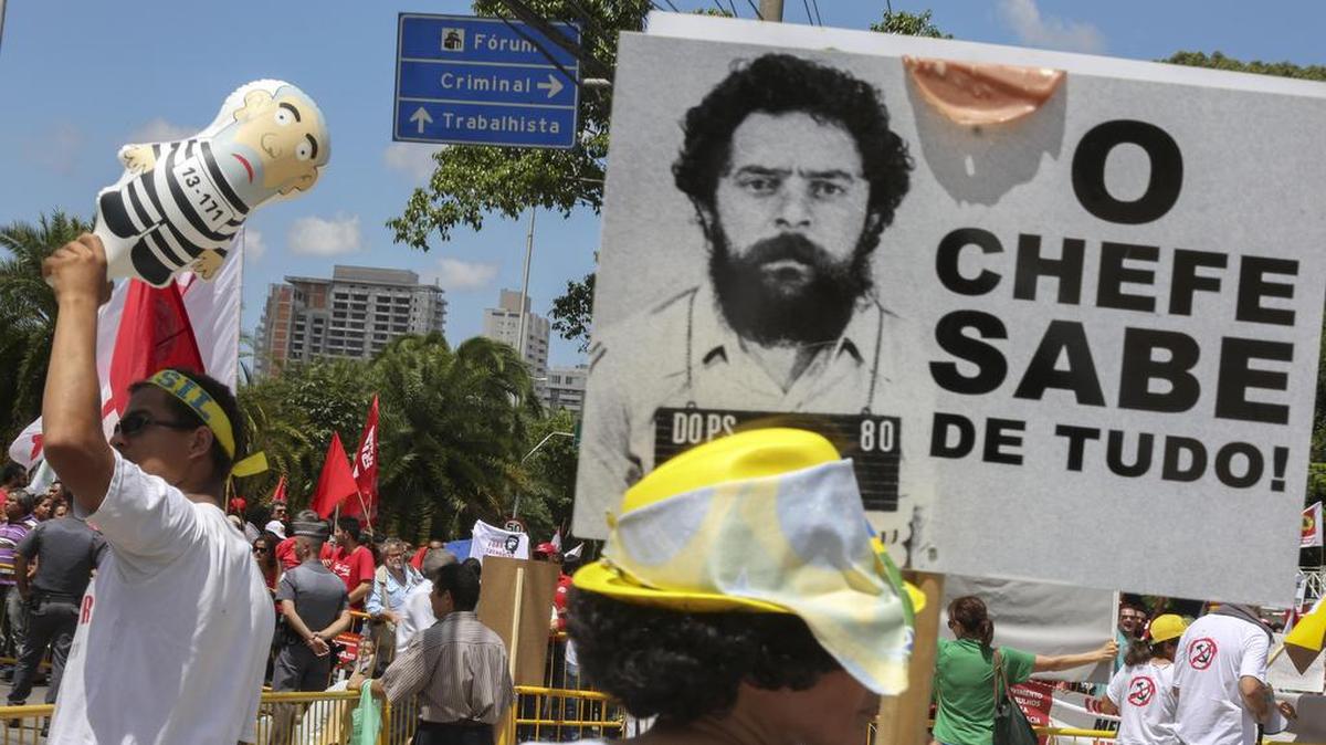 Manifestantes en favor y en contra del expresidente de Brasil Luiz Inácio Lula da Silva protestan el miércoles 17 de febrero de 2016, con carteles que rezan frases como "El jefe sabe de todo", a las afueras del Ministerio Público de Sao Paulo (Brasil) donde el exmandatario debía declarar como investigado por un supuesto caso de blanqueo de dinero, una audiencia que fue suspendida.
