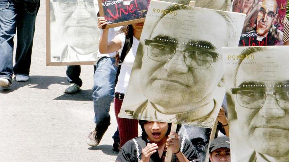 
Manifestantes desfilan llevando cartelones con la imagen del asesinado arzobispo Oscar Arnulfo Romero, en San Salvador.
