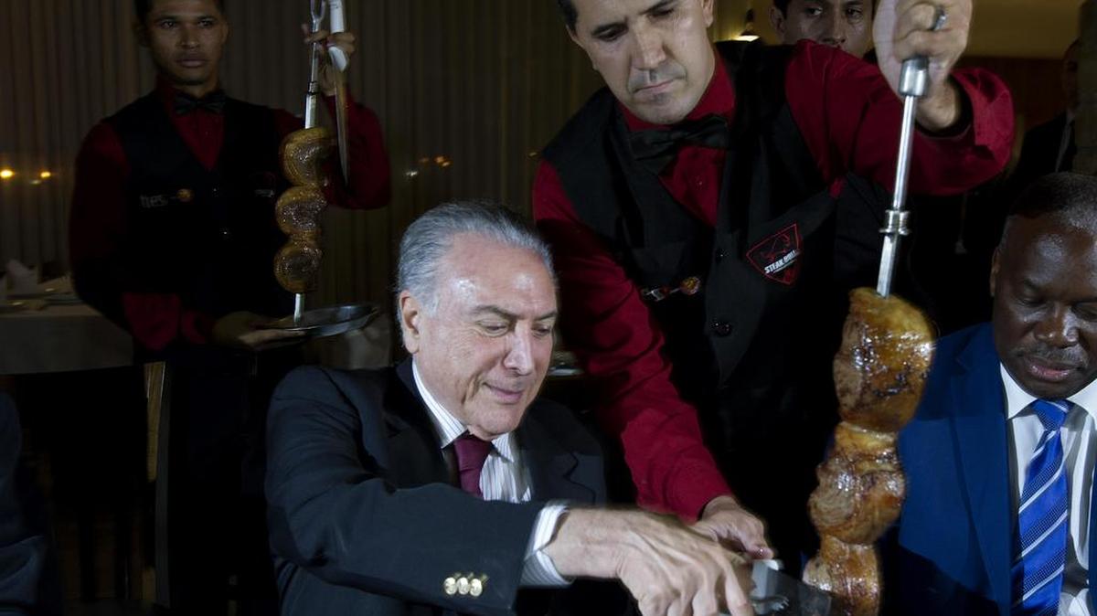 El presidente de Brasil, Michel Temer (c), participa en una cena de barbacoa tras una reunión de embajadores en el Palacio Presidencial el domingo 19 de marzo de 2017, en un asador Steak Bull en Brasilia (Brasil).