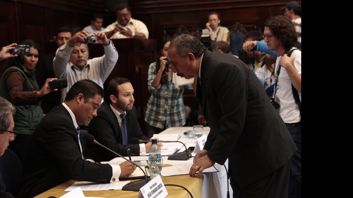
El abogado Carlos Alvarado (der.) en representación del presidente de Guatemala, Otto Pérez Molina, entrega un informe a la Comisión Investigadora del Congreso.
