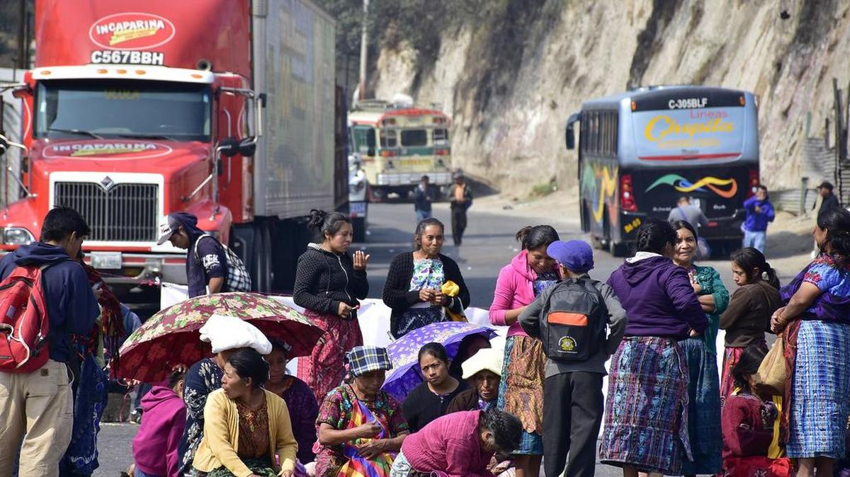 Un grupo de campesinos participa de una protesta convocada por la Coordinadora Nacional de Organizaciones Campesinas (CNOC) y el Comité de Desarrollo Campesino de Occidente (Codeca), que bloquearon el miércoles el paso en el sector de Cuatro Caminos.