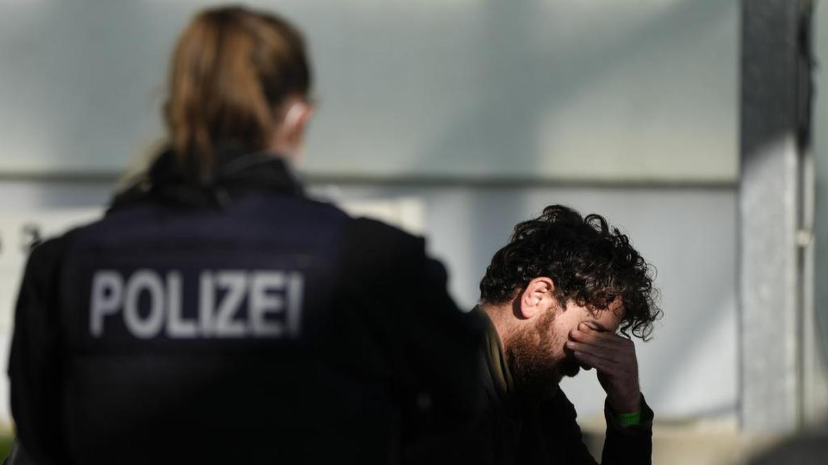 Foto de archivo. Una oficial de la policía federal alemana custodia a un migrante arrestado en una comisaría en Frankfurt.