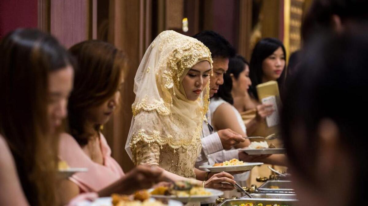 En esta fotografía tomada el 15 de enero de 2017, los huéspedes eligen alimentos durante una boda en el hotel Al Meroz en Bangkok