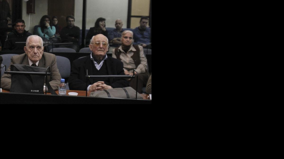
Los acusados Reynaldo Benito Bignone (izq.), Santiago Omar Riveros (cen.) y la obstetra Luisa Yolanda Arroche (der.atrás), asisten el miércoles al primer juicio contra médicos por su participación en las apropiaciones de niños nacidos en los centros de detención clandestinos.

