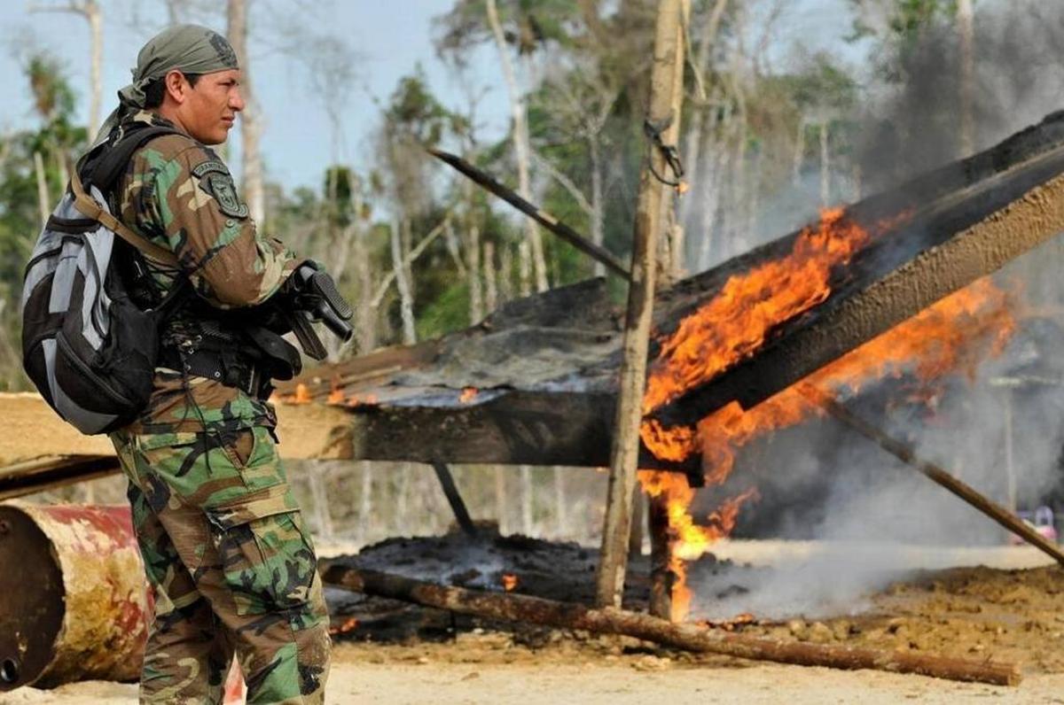 Un policía en el lugar donde las autoridades peruanas destruyeron excavadoras, dragas, motores y otros equipos pesados usados para extraer ilegalmente oro en la zona de Tambopata, en la región Madre de Dios, en una imagen del Ministerio del Interior de Perú.