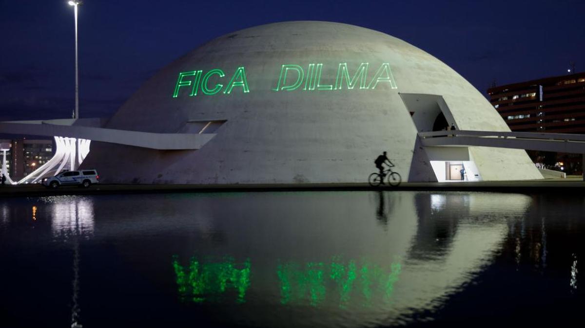 Un ciclista pasa frente al Museo de la República donde activistas proyectan la frase "quedate Dilma" el viernes 10 de junio de 2016, durante una protesta en la Esplanada de los Ministerios en Brasilia (Brasil).