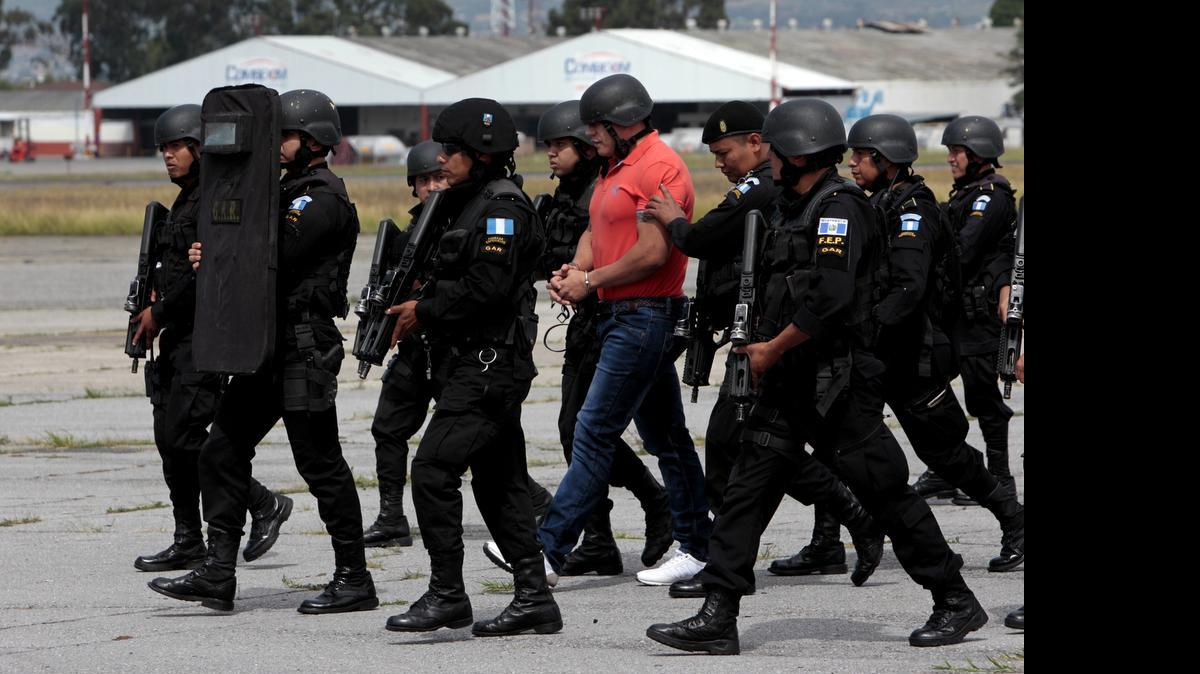 
Autoridades escoltan al supuesto capo del narcotráfico Jairo Orellana (cent.) durante su extradición el viernes, en Ciudad de Guatemala. 
