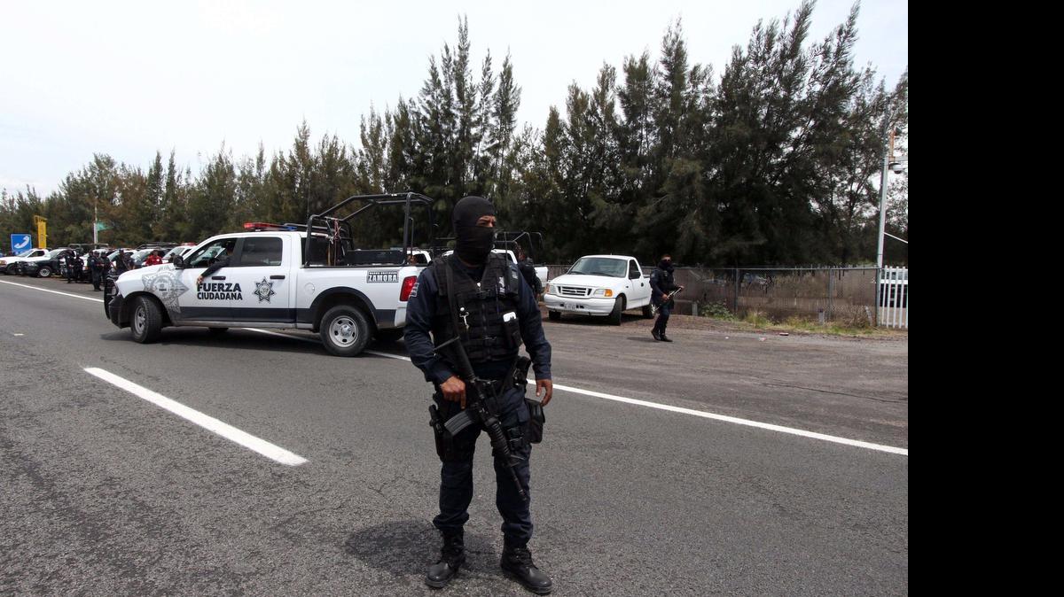 
Policías federales mexicanos vigilan el perímetro de la zona donde en medio de un inteso tiroteo la autoridades mataron cerca de 40 miembros de una banda de narcos en Vista Hermosa, estado de Michoacán, México.
