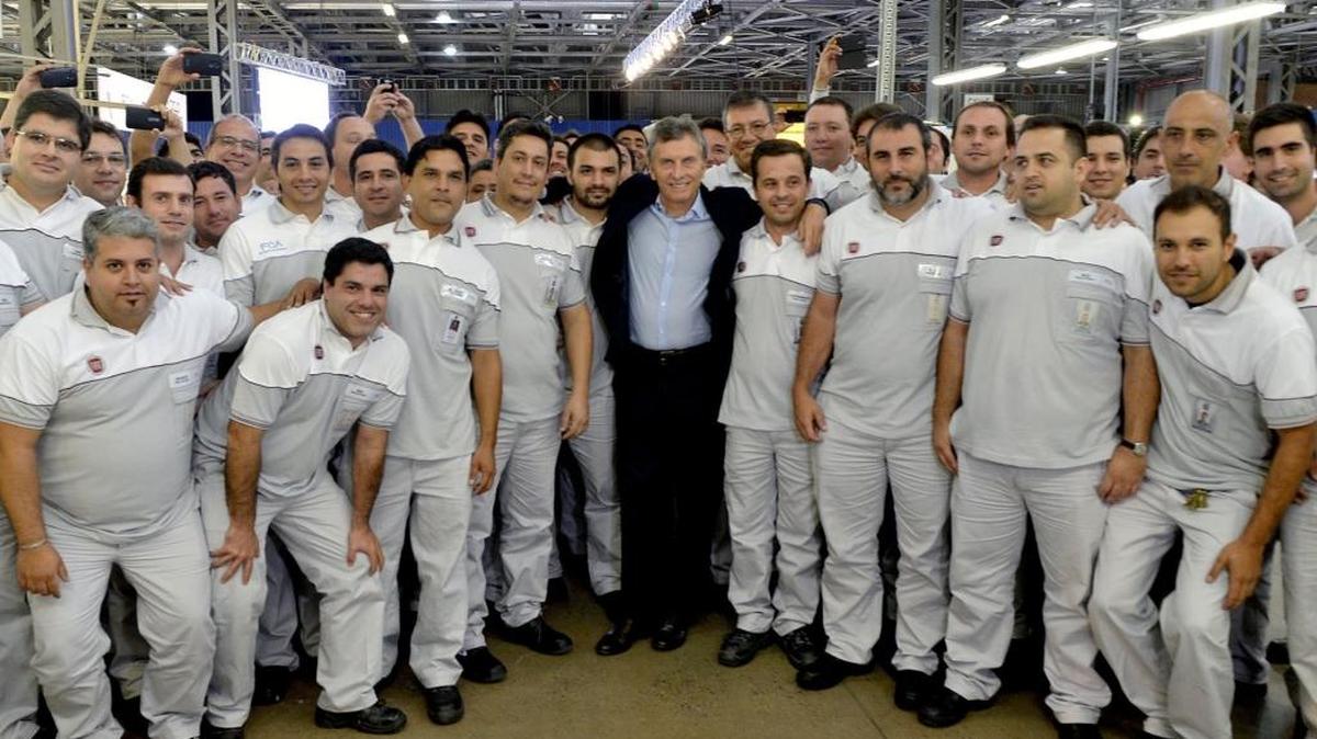 El presidente de Argentina, Mauricio Macri (cen.), posa el martes con trabajadores de una ensambladora de la FIAT en Córdoba.