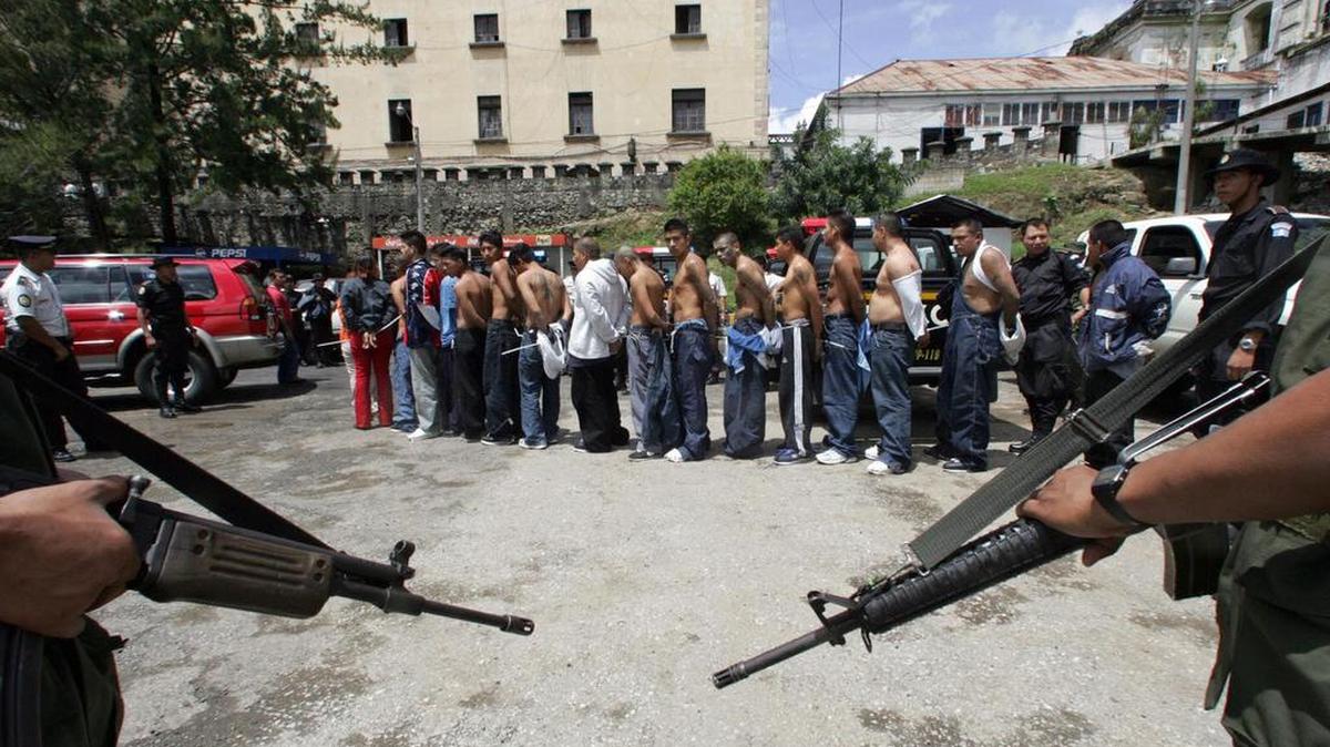 Los miembros de la banda "Mara 18" son escoltados después de su arresto durante una operación conjunta de la Policía Nacional Civil y el Ejército en el distrito guatemalteco de Mixco, al sur de la capital, el 21 de septiembre de 2005.