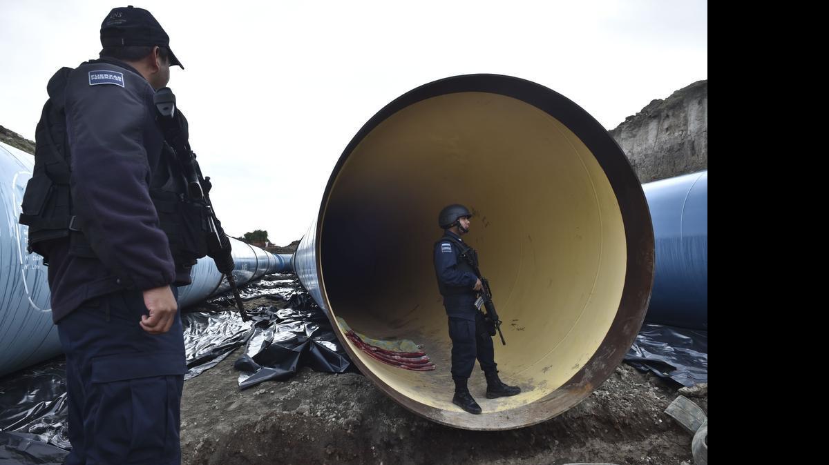 
Policías federales inspeccionan un sistema de tuberías en construcción en las cercanías del penal de alta seguridad El Altiplano, ubicado a 90 km de la capital, desde donde se fugó el pasado sábado “El Chapo” Guzmán.


