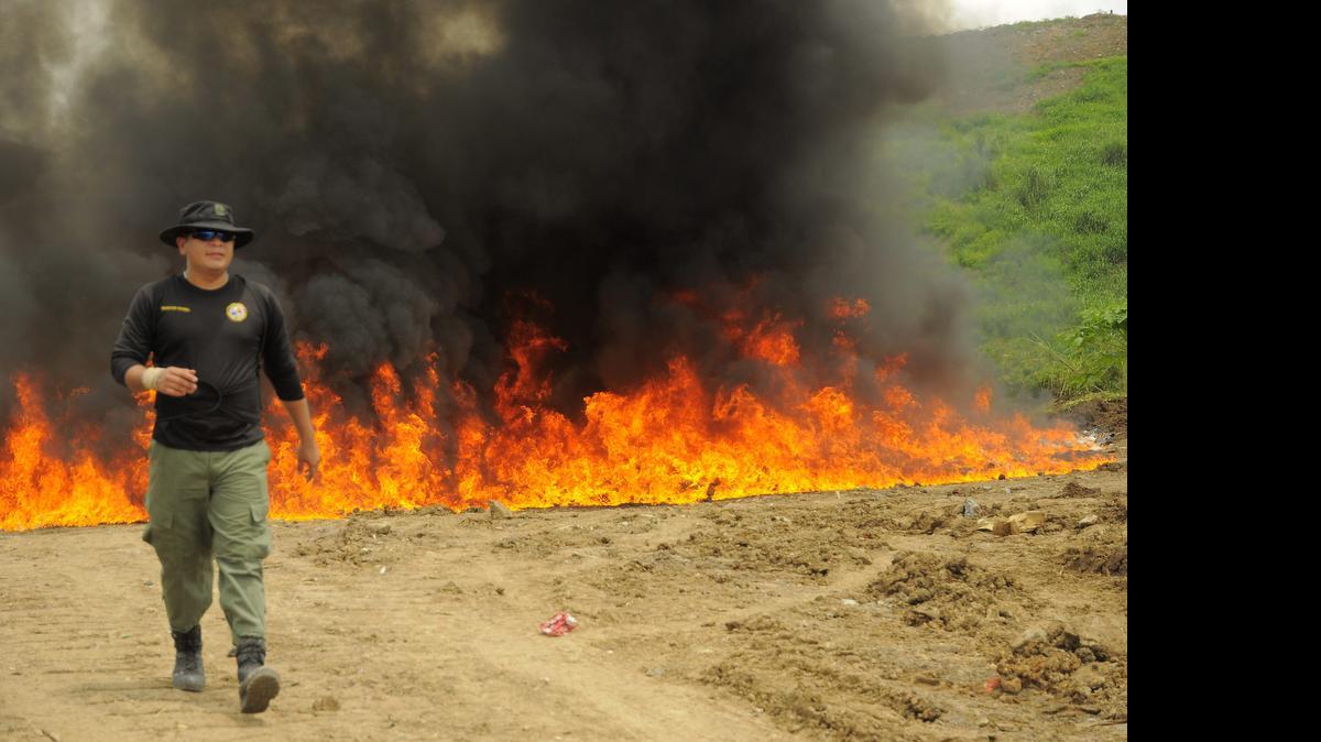 
Un funcionario antidrogas se aleja del fuego con el cual las autoridades destruyeron nueve toneladas de drogas decomisadas, en Ciudad de Panamá.
