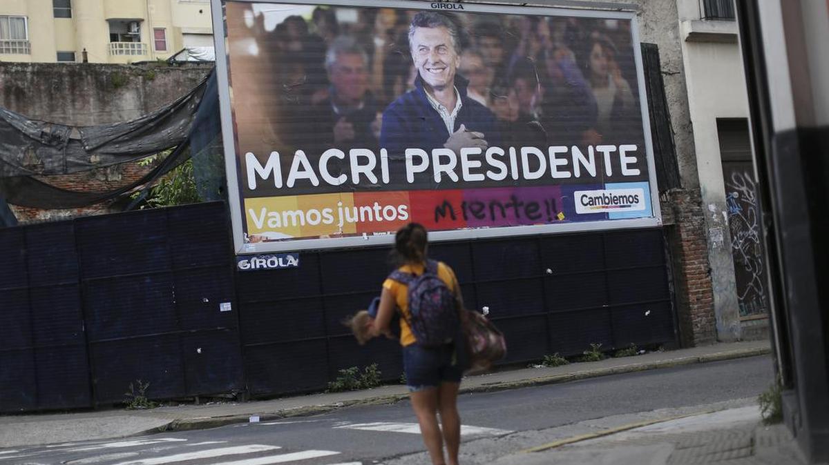 Una mujer camina frente a una valla de propaganda electoral del conservador Mauricio Macri el mièrcoles 18 de noviembre de 2015, en el centro de Buenos Aires (Argentina).