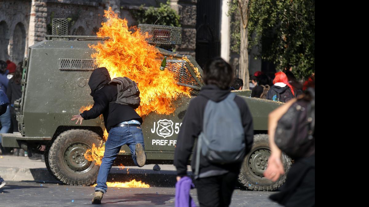 
Jóvenes se enfrentan con la policía el jueves en Santiago (Chile), para exigir al gobierno de Michelle Bachelet que deje de “hacerse el sordo” ante las demandas presentadas por el colectivo estudiantil en rechazo a la reforma educacional que impulsa el Ejecutivo. 
