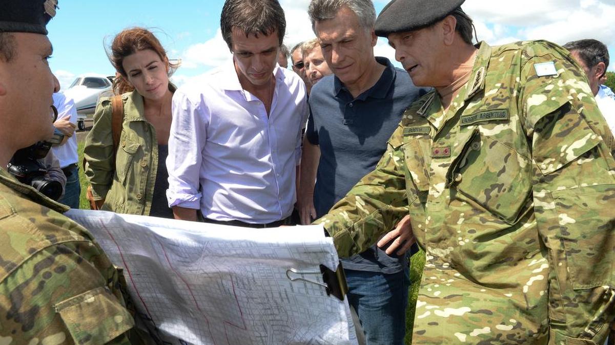 Fotografía cedida por la Presidencia de la Nación hoy, domingo 27 de diciembre de 2015, de el presidente argentino, Mauricio Macri (2i), examinando un mapa de las zonas afectadas por las inundaciones de los últimos días.