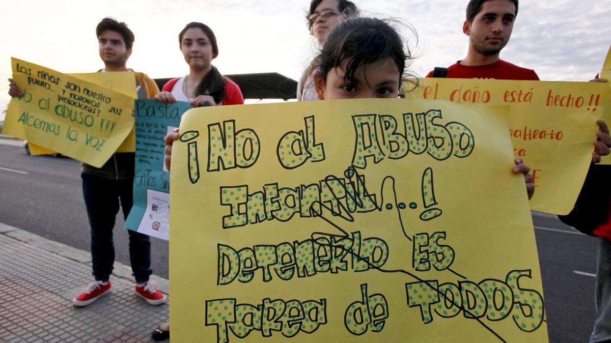 Una niña muestra un cartel que dice "No más maltrato infantil, es deber de todos detenerlo", durante una protesta contra el abuso sexual infantil en el centro de Asunción, Paraguay, 13 de mayo de 2015.