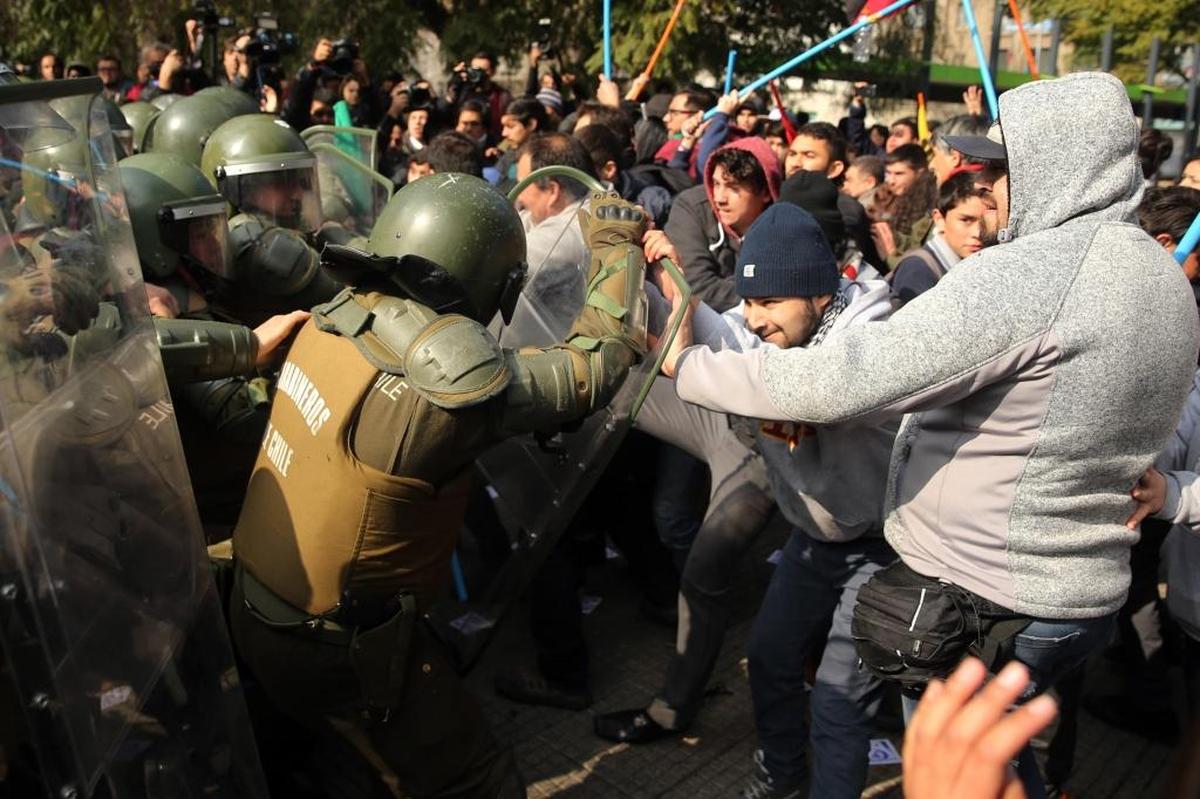 Agentes de la policía se enfrentan a manifestantes que exigen el fin del sistema privado de pensiones impuesto en 1981 por la dictadura de Augusto Pinochet en el primer aniversario de la Coordinadora Nacional de Trabajadores No+AFP.
